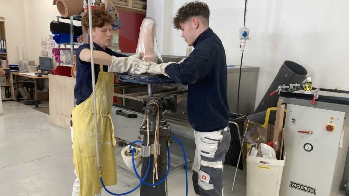 Zwei Mitarbeiter arbeiten an einem Anprobeschaft für eine Oberschenkelprothese (Bild: rbb/Annika Krempel)