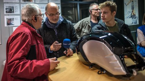 André Tonn spricht mit einem unserer Gewinner über den lackierten Tank auf dem Tisch (Bild: Dieter Freiberg)