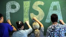 Schüler einer 9. Klasse malen das Wort "Pisa" an die Tafel (Bild: dpa)