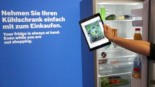 Eine Hostess präsentiert am 04.09.2015 auf der IFA in Berlin einen Kühlschrank von Bosch, der per eingebauter Kameras den Inhalt mittels einer App auf ein Tablet oder Smartphone verschickt. (Bild: dpa)