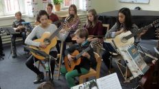 Eine Lehrerin unterrichtet eine Gitarrengruppe in einer Musikschule (Bild: imago)