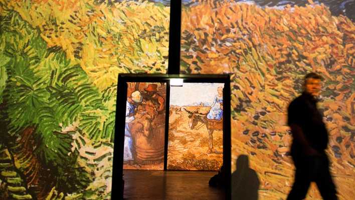Ein Besucher geht durch die Ausstellung "Van Gogh Alive" am 19.05.2015 in Berlin. (Bild: Jörg Carstensen/dpa)