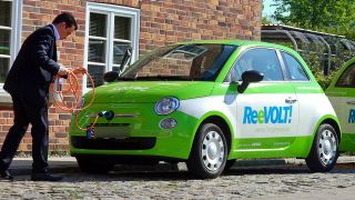 Ein Mitarbeiter schließt am 28.04.2014 auf dem Gelände des Energieversorgers Wemag in Schwerin (Mecklenburg-Vorpommern) ein Elektroauto auf Basis des Fiat 500 zum Aufladen an Stromtankstellen an. Foto: dpa