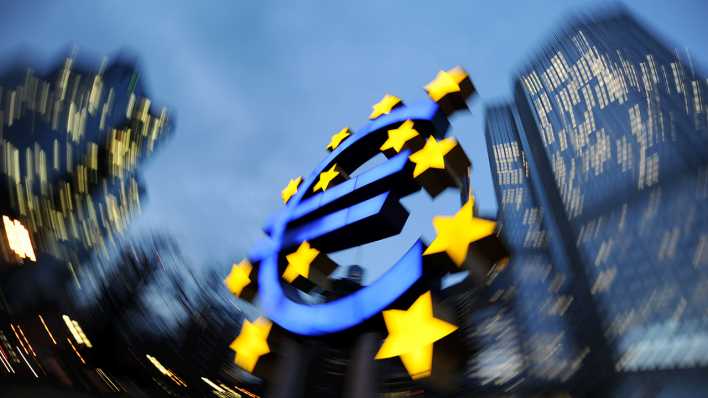 Die Euro-Skulptur leuchtet in Frankfurt am Main vor der Zentrale der Europäischen Zentralbank (EZB) (Bild: dpa)