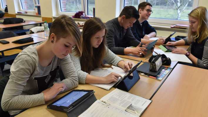 Schüler und Schülerinnen arbeiten am 04.03.2015 in ihrem Klassenzimmer am Tablet (Quelle: dpa)