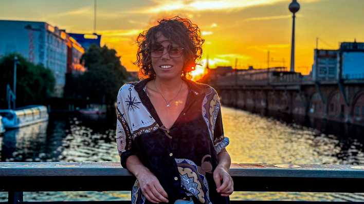 Technomusikerin Pilocka Krach steht bei Sonnenaufgang auf einer Spree-Bücke in Berlin-Mitte, Bild: rbb