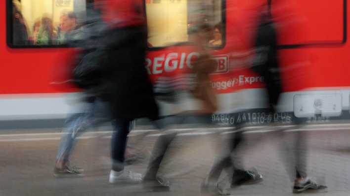 Symbolbild: Menschen vor einem Zug. (Quelle: imago)