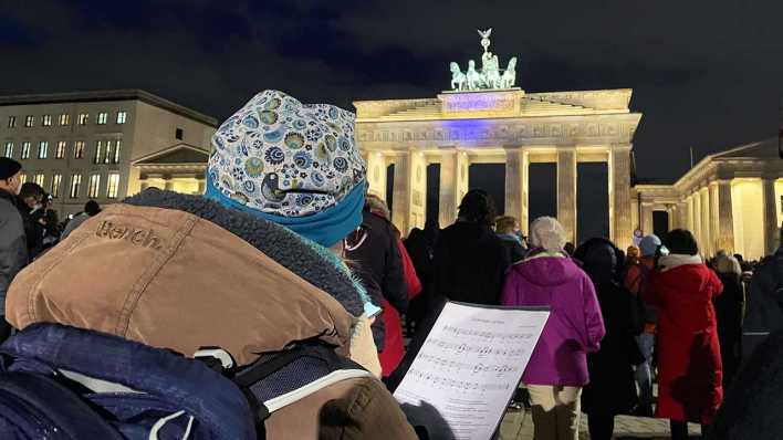 Menschen singen vor dem Brandenburger Tor (Quelle: rbb)