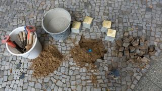 Archivbild: Der Kuenstler Gunter Demnig verlegt am 10.06.2013 vier Stolpersteine zum Gedenken an Opfer der NS-Zeit. (Quelle: dpa/Raphael Huenerfauth/photothek)