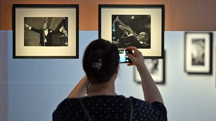 Eine Frau fotografiert während der Vorbesichtigung der Ausstellung "I've Seen the Wall" im Kunsthaus Minsk eines der Fotos aus der Serie „Louis Armstrong bei einem Auftritt in der DDR im März 1965“ des Fotografen T.Leher. (Quelle: dpa/Soeren Stache)